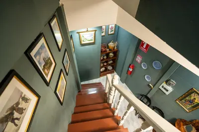 an overhead view of a staircase with paintings on the walls at The Unforgotten B&B in Bangkok