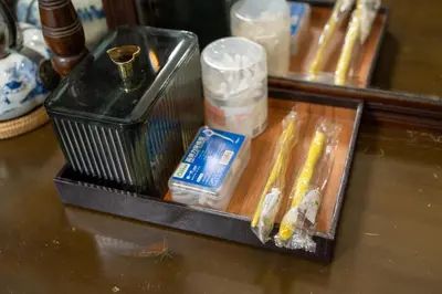 a table with a tray with tooth brushes and a mirror at The Unforgotten B&B in Bangkok