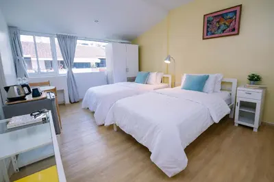 a room with two beds and a mirror at K Home Asok in Bangkok