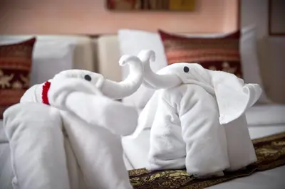 two stuffed elephants are sitting on a bed at KC Place Hotel Pratunam in Bangkok