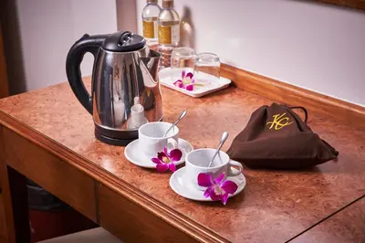 a counter with two cups and a tea kettle on it at KC Place Hotel Pratunam in Bangkok