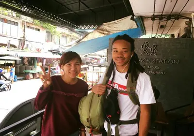 a man and a woman standing next to a car at Backpack Station in Bangkok