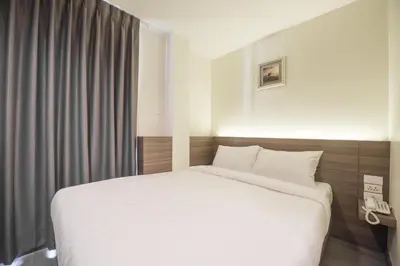 a bedroom with a white bed and a window at Sovereign Group Hotel at Pratunam in Bangkok