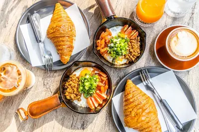 a table topped with plates of food and drinks at Baan 2459 Heritage House in Bangkok