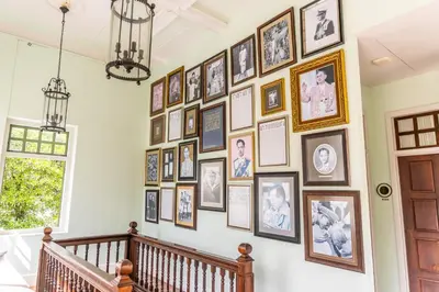 a hallway with a wall of pictures on the wall at Baan 2459 Heritage House in Bangkok
