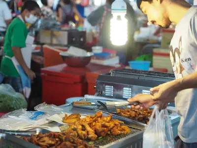 a man is preparing food on a grill at 28 Place in Bangkok