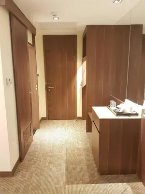 a hallway of a hotel room with wooden doors at Louis Tavern Hotel in Bangkok