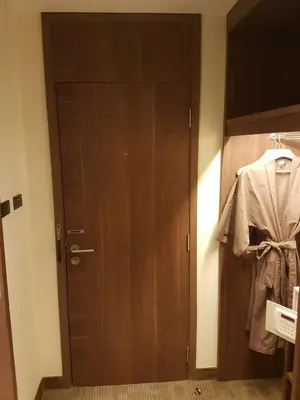 a wooden door with a shirt hanging on it at Louis Tavern Hotel in Bangkok