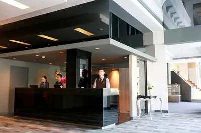 a lobby with people standing at a reception desk at Louis Tavern Hotel in Bangkok