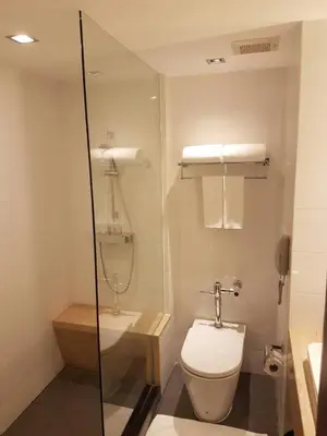 a bathroom with a toilet and a sink at Louis Tavern Hotel in Bangkok