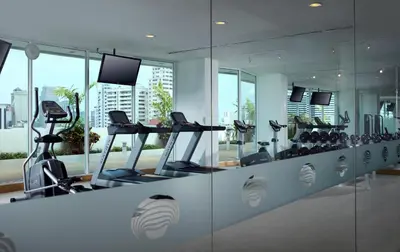 a gym with treadmills and elliptical machines at Shama Sukhumvit Bangkok in Bangkok