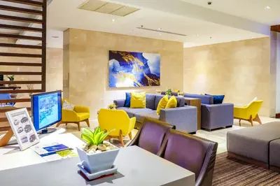 a living room with yellow chairs and a couch at Shama Sukhumvit Bangkok in Bangkok