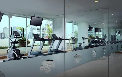 a gym with treadmills and elliptical machines at Shama Sukhumvit Bangkok in Bangkok