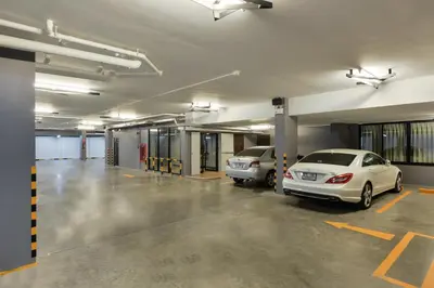 a parking garage with two cars parked in it at SiRi Ratchada Bangkok in Bangkok