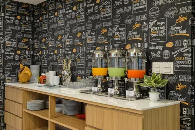 a restaurant with a black and white wall and a counter at SiRi Ratchada Bangkok in Bangkok