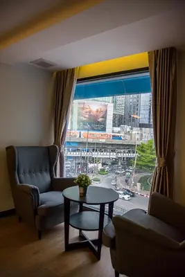 a living room with a couch and a table and a large window at The Connex Asoke in Bangkok