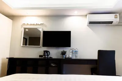 a bedroom with a desk with a television and a mirror at The Connex Asoke in Bangkok