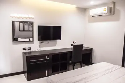 a bedroom with a desk with a tv and a bed at The Connex Asoke in Bangkok
