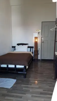 a bedroom with a bed and a wooden floor at Lamphuhouse Bangkok in Bangkok