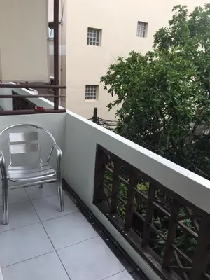 a chair sitting on the balcony of a building at Lamphuhouse Bangkok in Bangkok