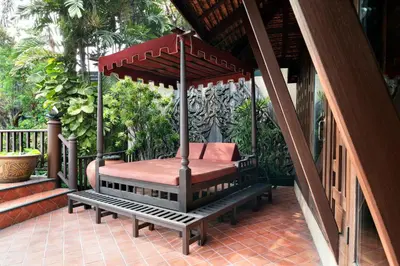 a gazebo with a swing on a porch at Chakrabongse Villas in Bangkok