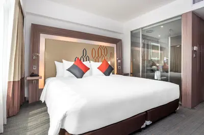 a large bedroom with a large white bed with pillows at Hilton Garden Inn Bangkok Silom in Bangkok