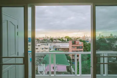 a view of a city from an open window at S.E.T Thanmongkol Residence in Bangkok