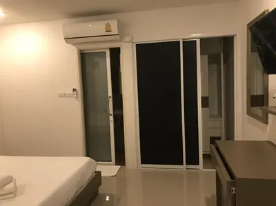 a bedroom with a bed and a large window at S.E.T Thanmongkol Residence in Bangkok