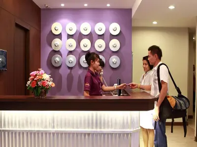 a group of people standing at a reception counter at Sawasdee Hotel @ Sukhumvit Soi 8 in Bangkok