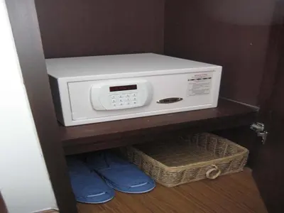 a microwave oven on a shelf in a closet at Sawasdee Hotel @ Sukhumvit Soi 8 in Bangkok