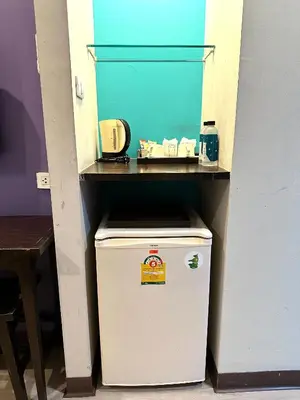 a small refrigerator with a shelf on top of it at Sawasdee Hotel @ Sukhumvit Soi 8 in Bangkok