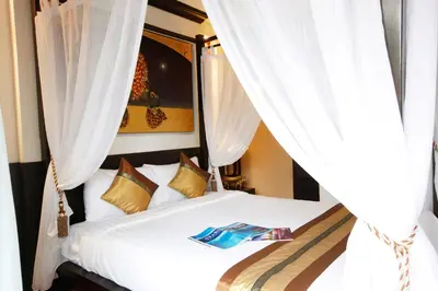 a bedroom with a bed with white curtains at Mirth Sathorn Hotel in Bangkok