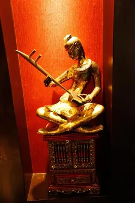 a bronze statue of a woman playing a guitar at Mirth Sathorn Hotel in Bangkok