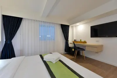 a hotel room with a bed and a desk and a television at iCheck inn Sukhumvit 19 in Bangkok
