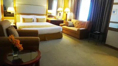 a hotel room with a bed and a couch at Arnoma Hotel Bangkok in Bangkok