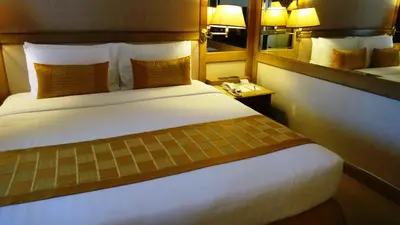 a hotel room with a large bed and a mirror at Arnoma Hotel Bangkok in Bangkok
