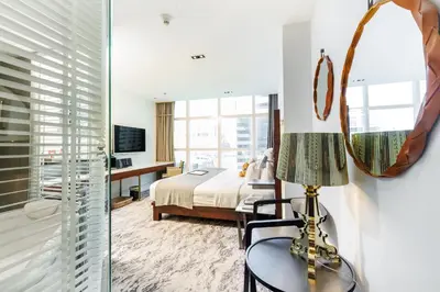 a bedroom with a bed and a mirror at S31 Sukhumvit Hotel in Bangkok