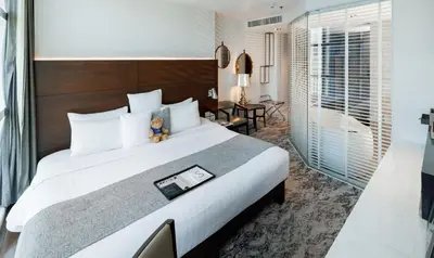 a hotel room with a large bed and a bathroom at S31 Sukhumvit Hotel in Bangkok
