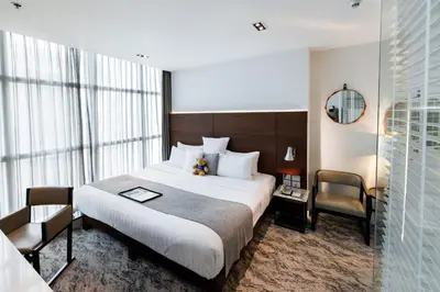 a bedroom with a large bed and a large window at S31 Sukhumvit Hotel in Bangkok