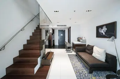 a living room with a staircase and a couch at S31 Sukhumvit Hotel in Bangkok
