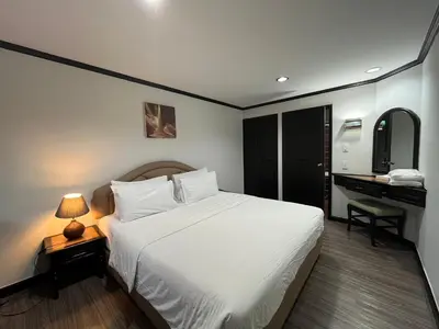 a bedroom with a large white bed and a desk at Yellow Ribbon Hills Boutique Suites in Bangkok
