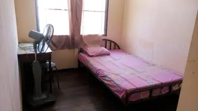 a small bed in a room with a window at Anurak Guesthouse in Bangkok
