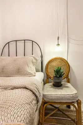 a bedroom with a bed and a chair with a potted plant at Klong House in Bangkok