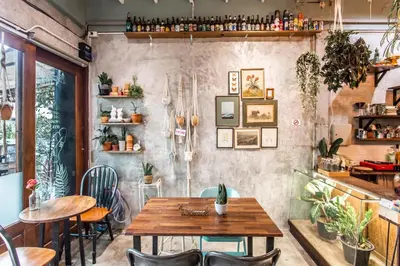a restaurant with a wooden table and chairs at Klong House in Bangkok