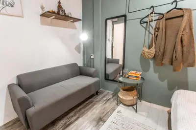 a living room with a couch and a mirror at Klong House in Bangkok