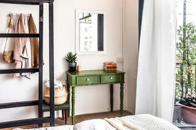 a green table in a bedroom with a mirror at Klong House in Bangkok