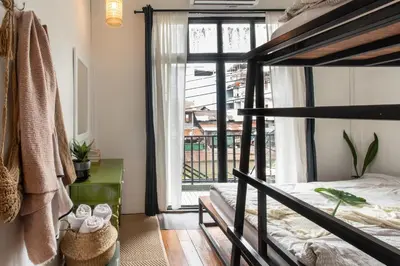 a bedroom with a bunk bed and a window at Klong House in Bangkok