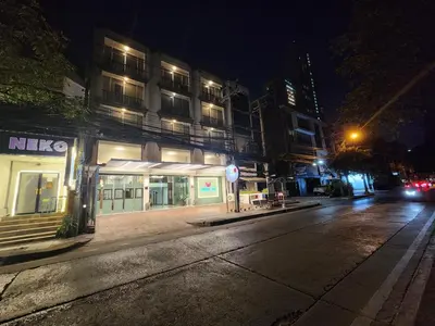 an empty city street at night with a building at August Residence in Bangkok
