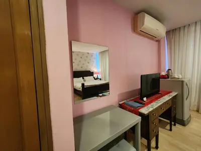 a room with a mirror and a desk with a television at August Residence in Bangkok