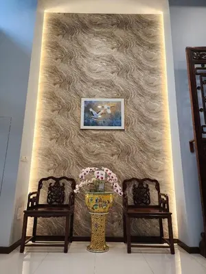 a wall with two chairs and a vase with flowers at August Residence in Bangkok
